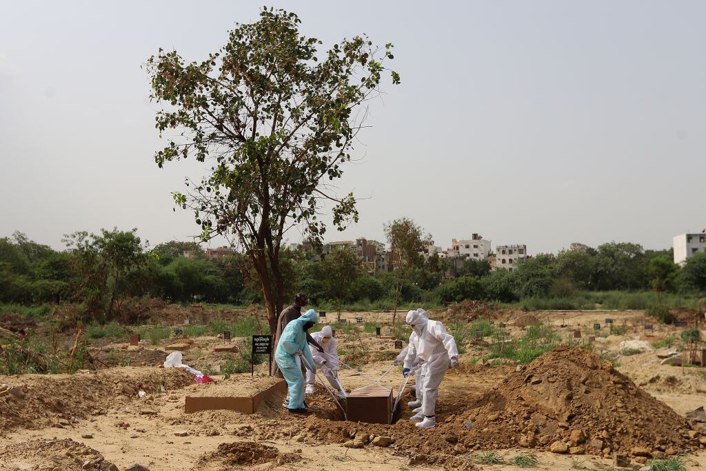 Trabajadores entierran a una víctima del Covid-19 en India