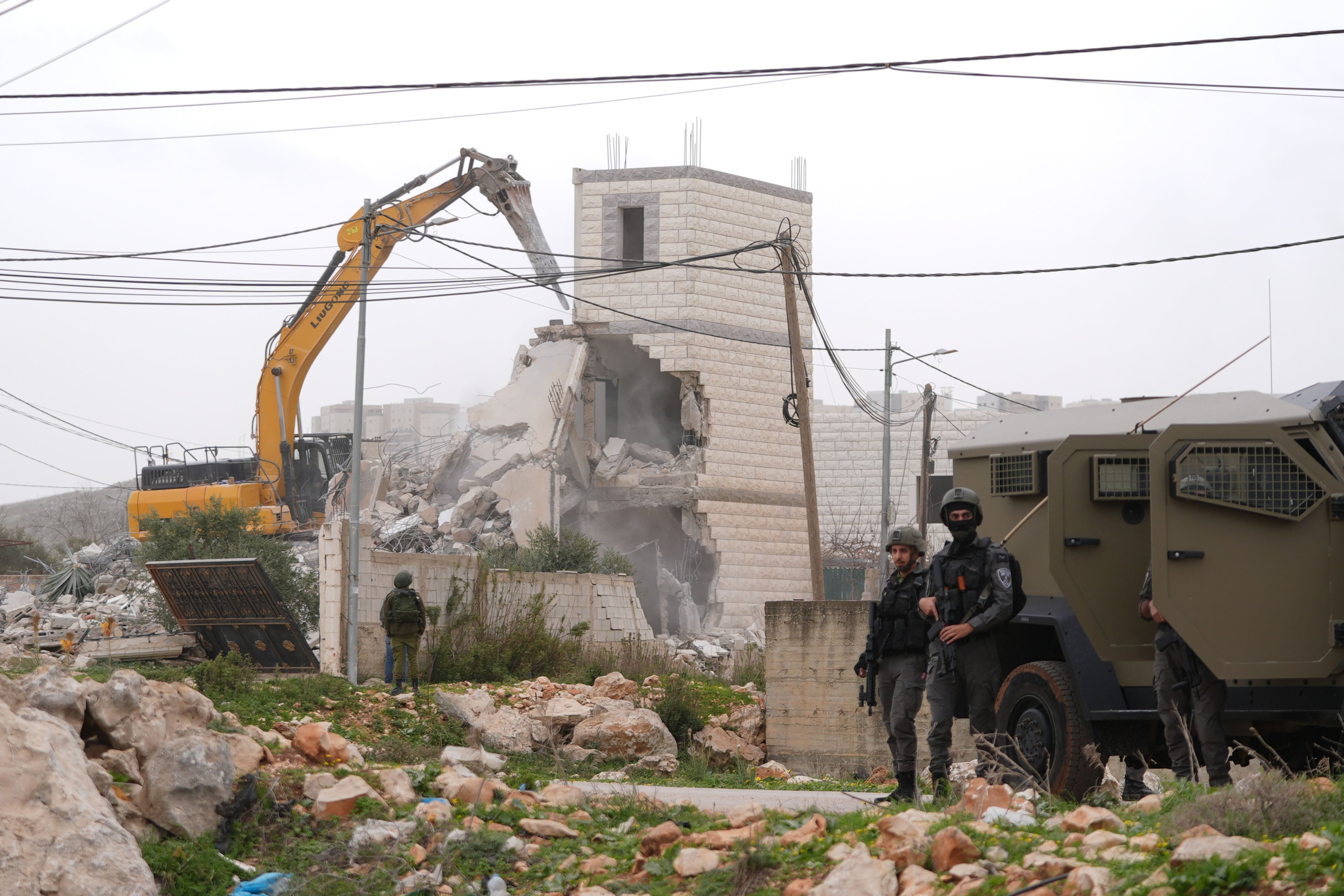 Fuerzas israelíes demuelen un edificio de dos pisos propiedad de palestinos durante una incursión militar en Cisjordania. (Foto de Issam Rimawi/Anadolu vía Getty Images)