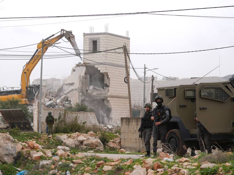 Fuerzas israelíes demuelen un edificio de dos pisos propiedad de palestinos durante una incursión militar en Cisjordania. (Foto de Issam Rimawi/Anadolu vía Getty Images)