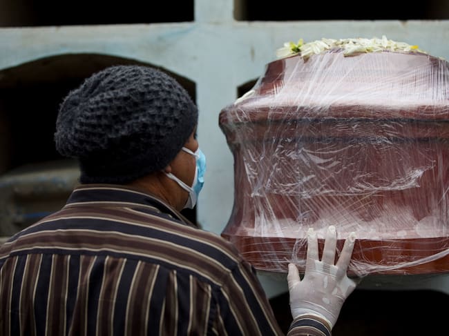 Trabajadores de un cementerio de Lima entierra a una víctima del Covid-19