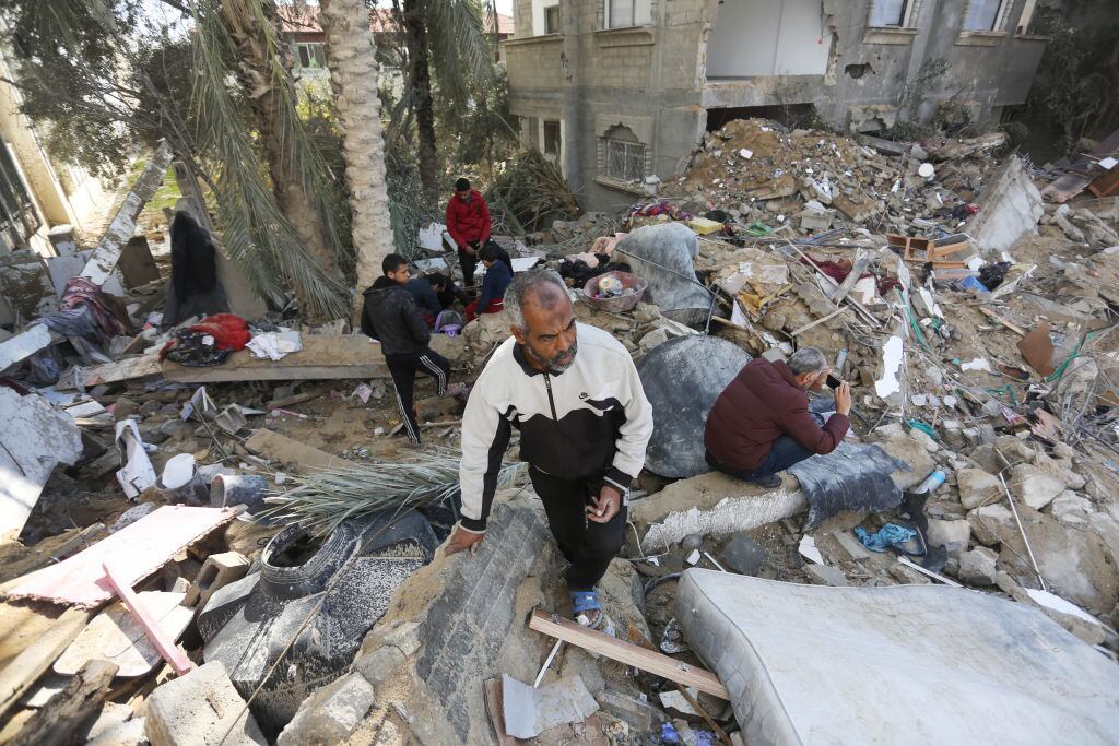 Las personas buscan en medio de los escombros que dejan los bombardeos de Israel sobre la zona de Deir al Balah en la Franja de Gaza.