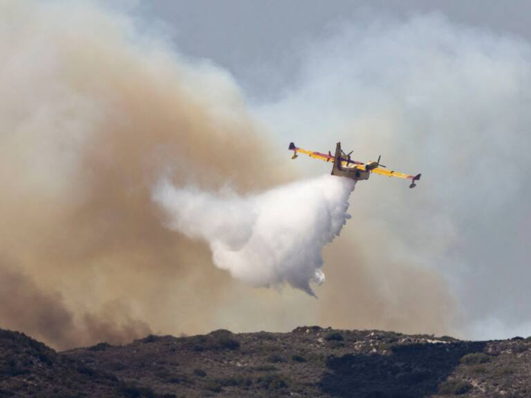 Avión lanza agua sobre un incendio forestal en Grecia y cerca del Mediterráneo