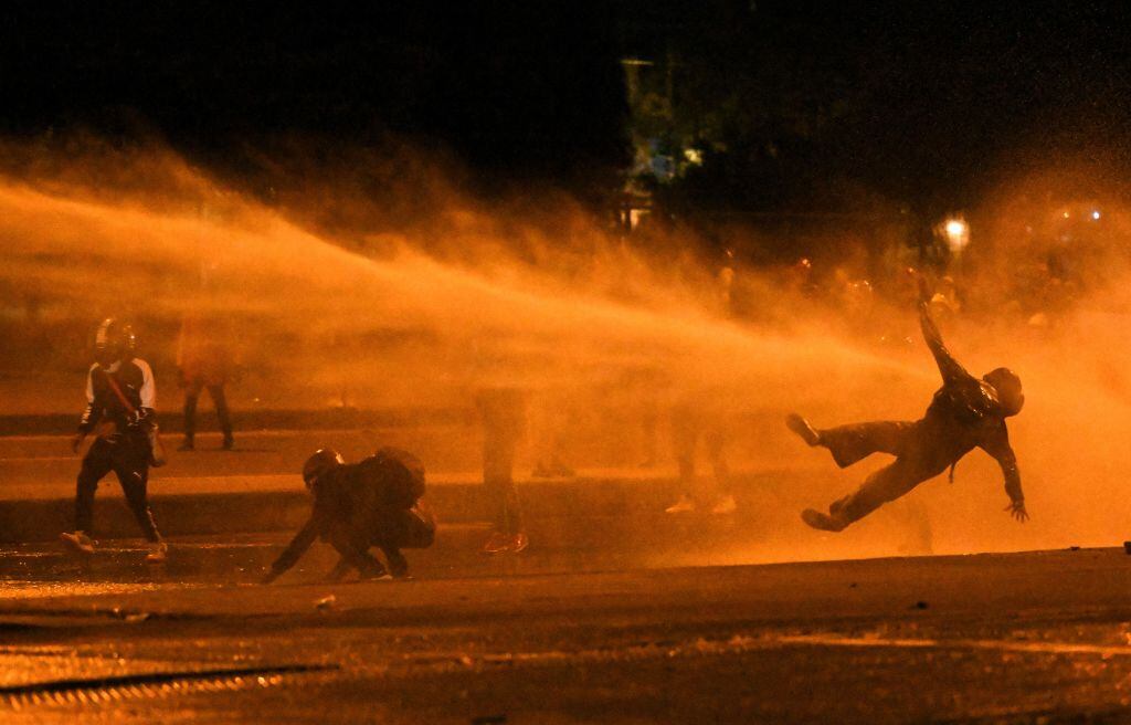 Carro lanzagua hace caer a un manifestante anti gobierno en Bogotá