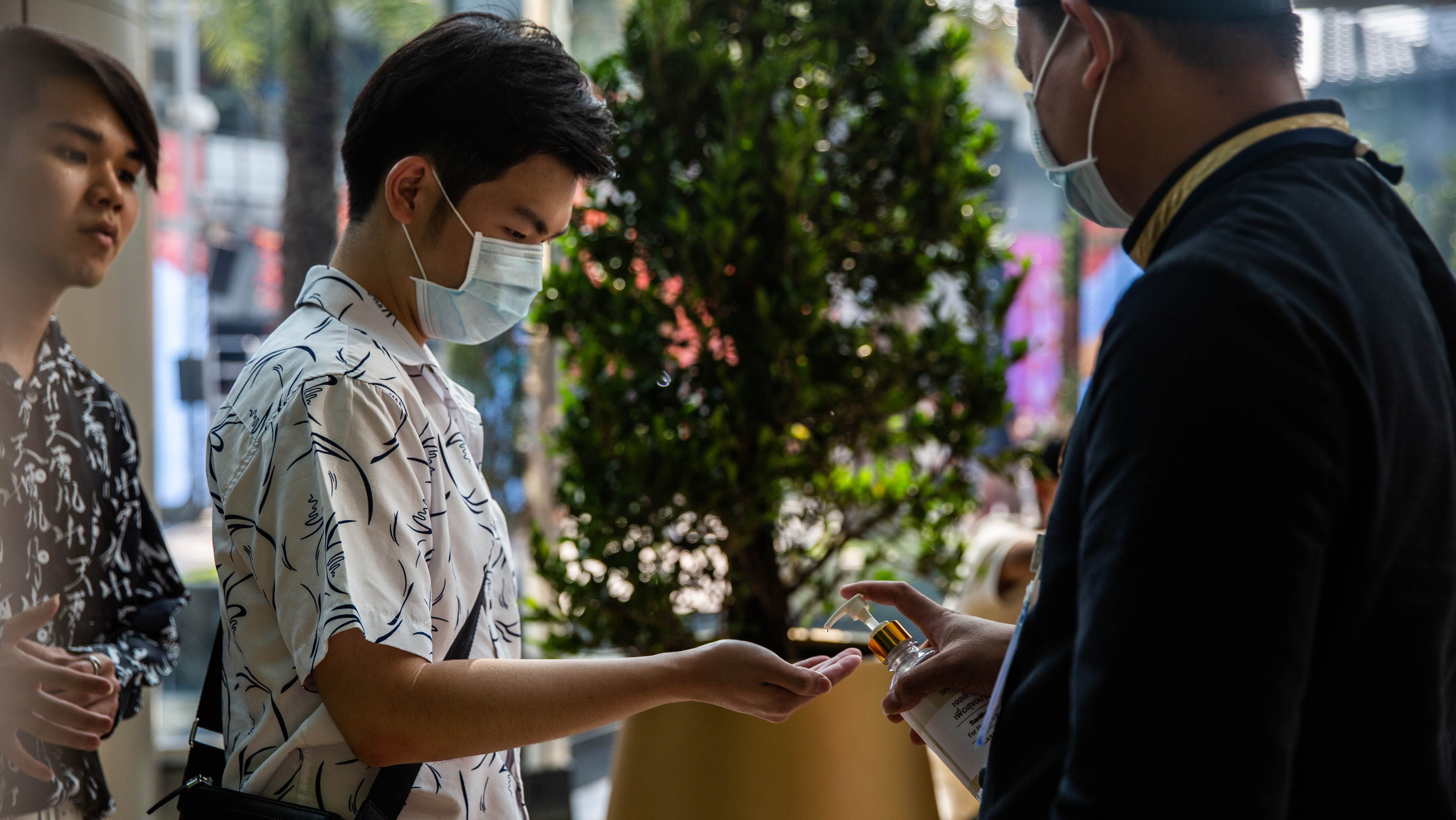 BANGKOK, THAILAND - FEBRUARY 08: People wearing face-masks visit a hand sanitizer station at Siam Paragon Mall on February 8, 2020 in Bangkok, Thailand. As Thailand confirms its 32nd case of the 2019 Novel Coronavirus and face mask supplies dwindle in stores, Thailand's Ministry of Defence assigned the Army's Medical Department, Phramongkutklao Hospital and the Royal Thai Army Nursing College to send officials to distribute masks to people in crowded tourist areas of Bangkok which are deemed most at risk for spread of the virus. (Photo by Lauren DeCicca/Getty Images)