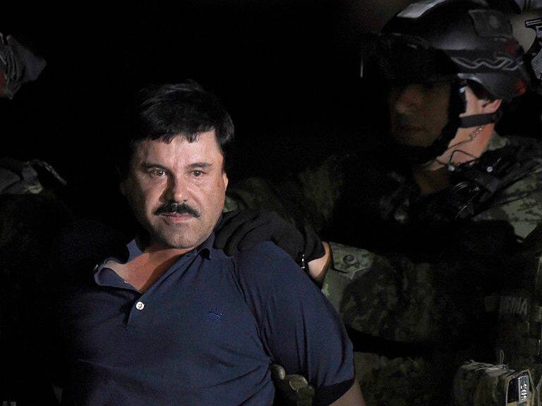 TOPSHOT - Drug kingpin Joaquin "El Chapo" Guzman is escorted into a helicopter at Mexico City's airport on January 8, 2016 following his recapture during an intense military operation in Los Mochis, in Sinaloa State. Mexican marines recaptured fugitive drug kingpin Joaquin "El Chapo" Guzman on Friday in the northwest of the country, six months after his spectacular prison break embarrassed authorities. AFP PHOTO / ALFREDO ESTRELLA / AFP / ALFREDO ESTRELLA (Photo credit should read ALFREDO ESTRELLA/AFP via Getty Images)