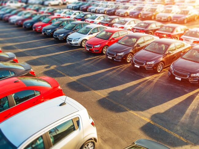 Dealer New Cars Stock. Colorful Brand New Compact Vehicles For Sale Awaiting on the Dealer Parking Lot. Car Market Business Concept.