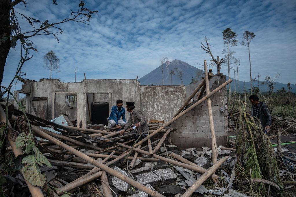 Personas observan el daño del volcán Semeru en las villas de la isla de Java