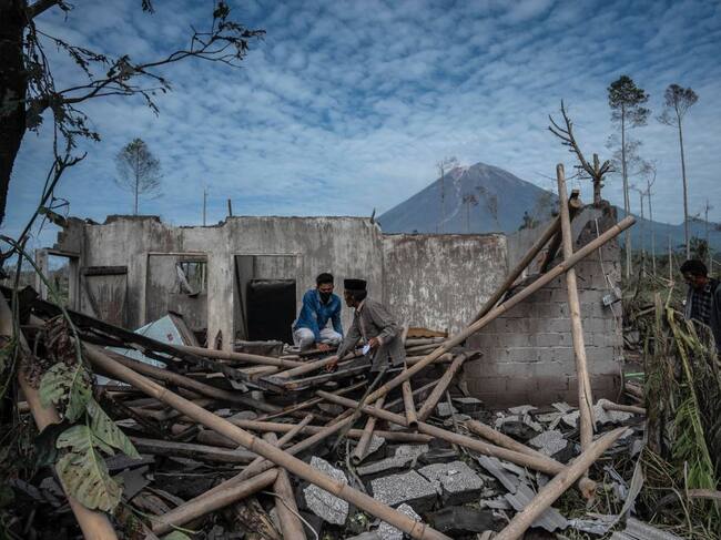 Personas observan el daño del volcán Semeru en las villas de la isla de Java