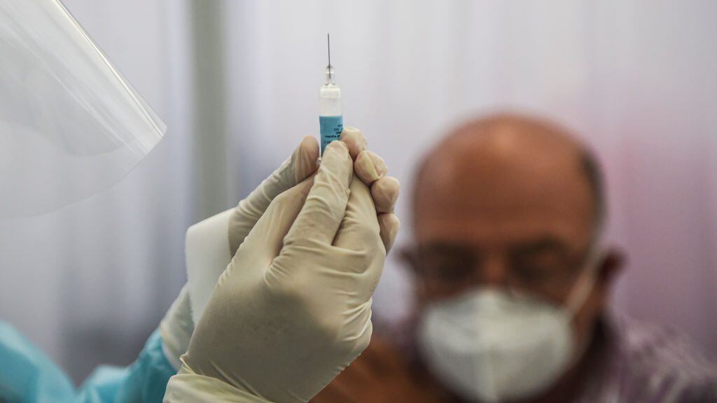 A health worker prepares a syringe to inoculate a volunteer with a COVID-19 vaccine produced by the Chinese Sinopharm during its trial at the Clinical Studies Center of the Cayetano Heredia University in Lima on December 09, 2020. (Photo by ERNESTO BENAVIDES / AFP) (Photo by ERNESTO BENAVIDES/AFP via Getty Images)