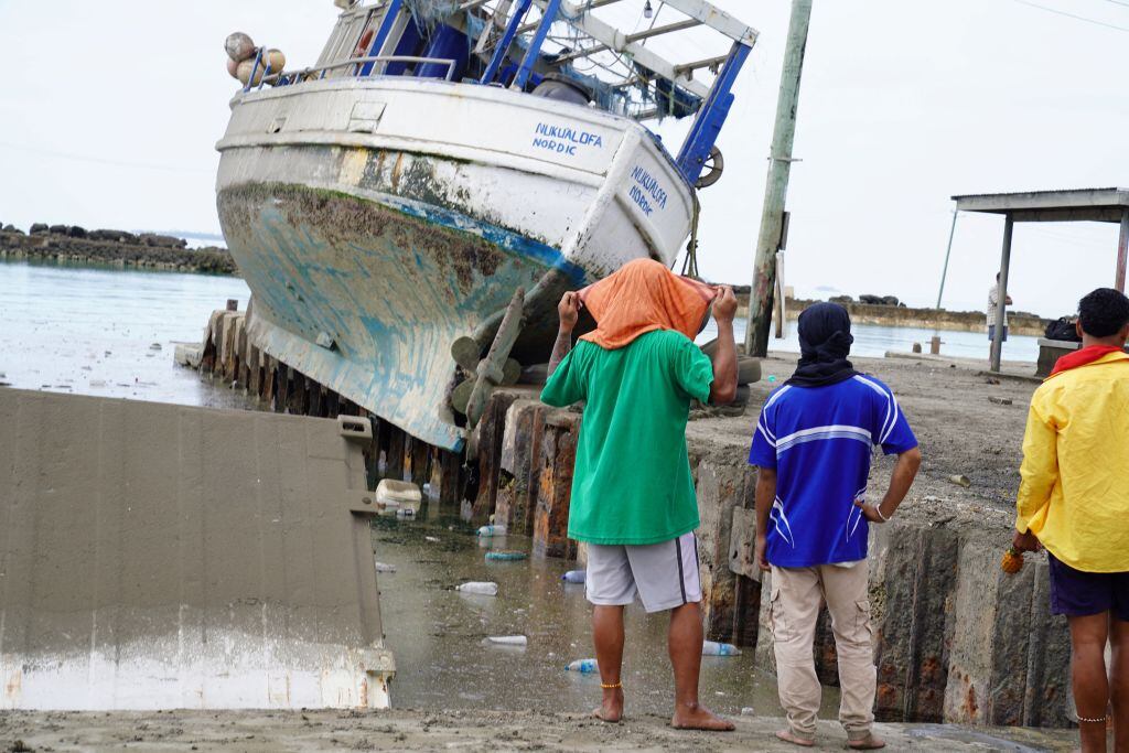 Un barco pesquero sobre un muelle en ,a capital Nukualofa de Tonga