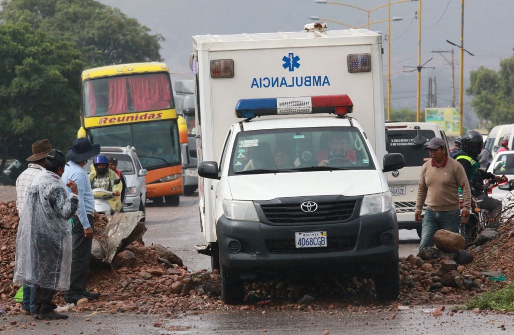 Una ambulancia logra sortear un corte de carretera en Bolivia, en medio de las protestas de grupos que exigen que Evo Morales pueda ser candidato presidencial.