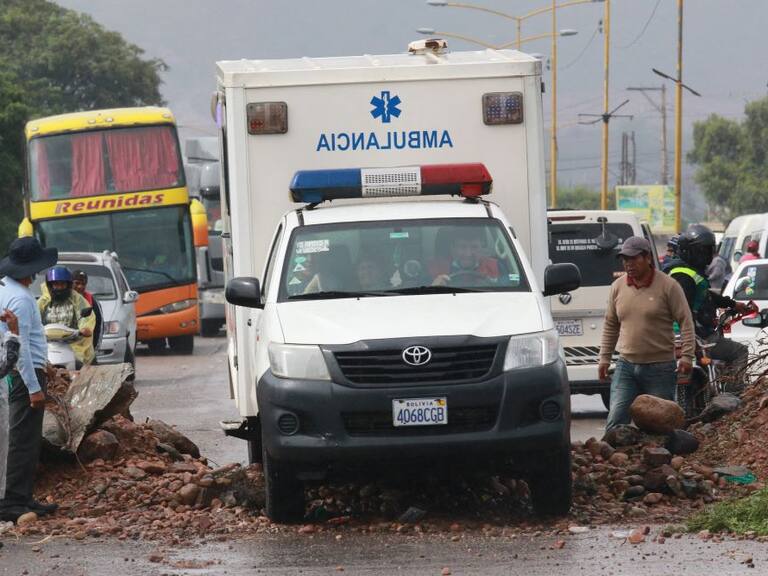 Una ambulancia logra sortear un corte de carretera en Bolivia, en medio de las protestas de grupos que exigen que Evo Morales pueda ser candidato presidencial.