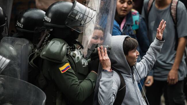 Un efectivo policial reprime una protesta estudiantil en la ciudad de Bogotá