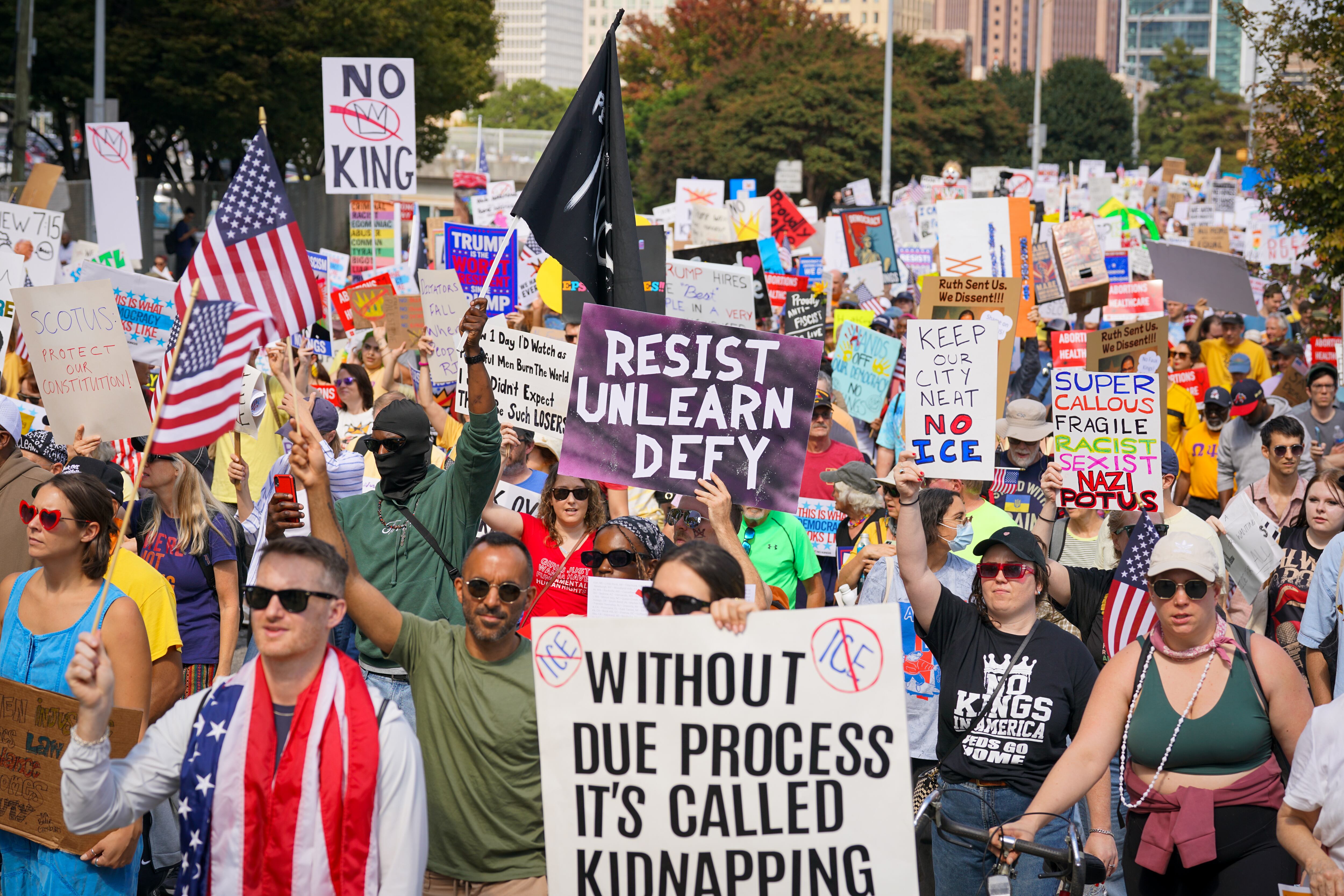 ATLANTA, GEORGIA - OCTOBER 18: Demonstrators hold protest signs during a march from the Atlanta Civic Center to the Georgia State Capitol on October 18, 2025 in Atlanta, Georgia. Organizers expect millions to participate in cities and towns across the nation for the second "No Kings" protest to denounce the Trump administration. (Photo by Julia Beverly/Getty Images)