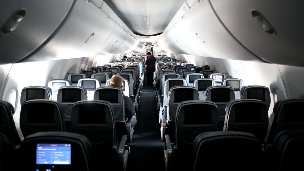 IN FLIGHT - APRIL 20: A flight attendant checks on passengers mid-flight on a Baltimore, Maryland bound Delta flight from Hartsfield-Jackson Atlanta International Airport on April 20, 2020 in Atlanta, Georgia. The airline industry has been hit hard by the COVID-19 pandemic, forcing the cancellation and consolidation of flights across the globe. (Photo by Rob Carr/Getty Images)