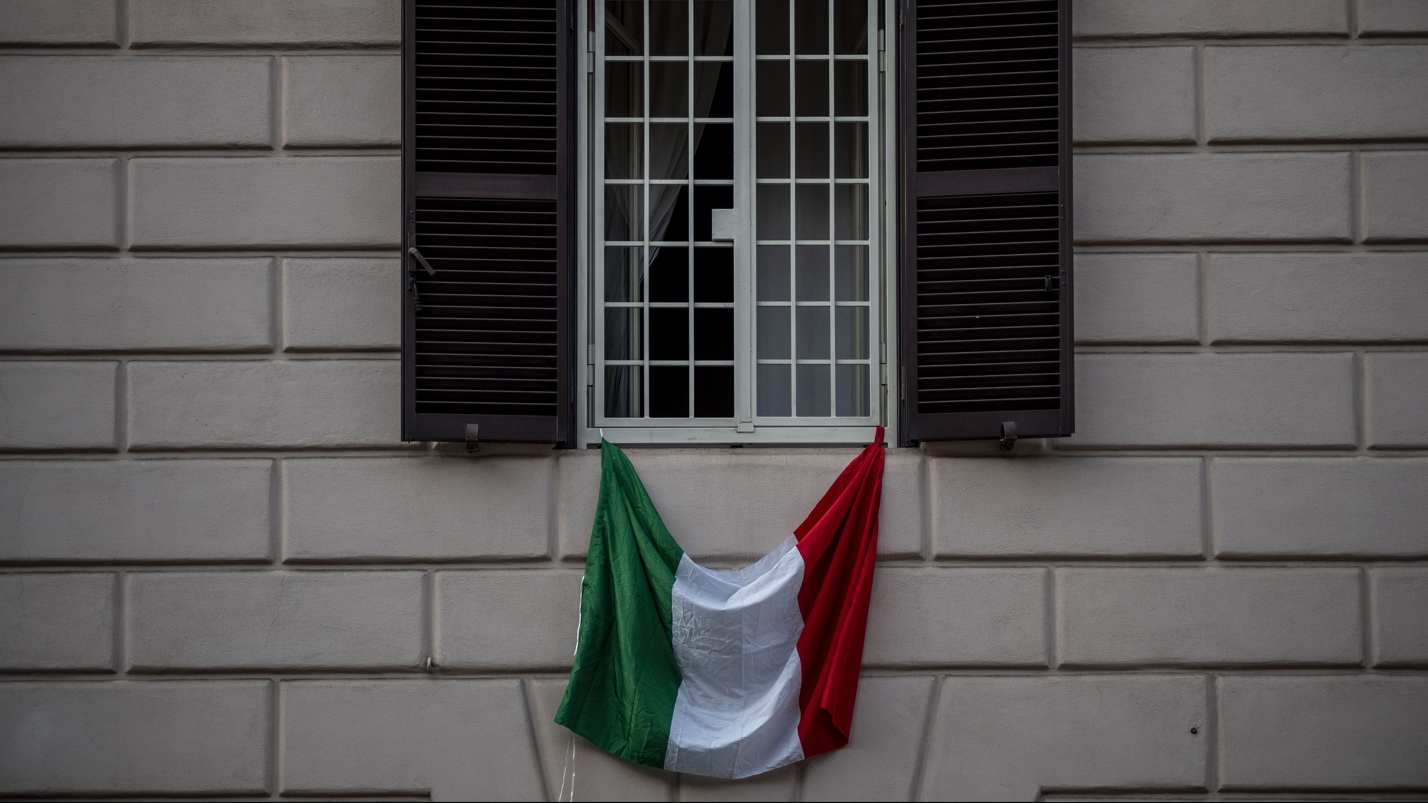 ROME, ITALY - MARCH 22: The Italian national flag hangs from a balcony during the Coronavirus emergency, on March 22, 2020 in Rome, Italy. The Italian government continues to enforce the nationwide lockdown measures to control the spread of COVID-19. (Photo by Antonio Masiello/Getty Images)