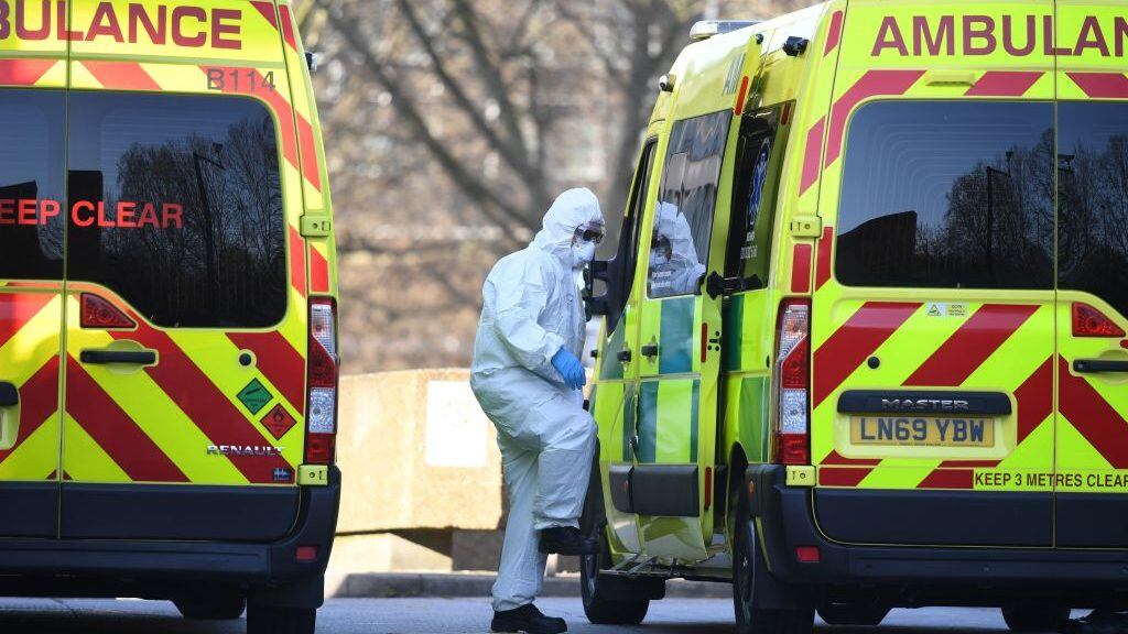 A member of the ambulance service wearing personal protective equipment is seen leading a patient (unseen) into an ambulance at St Thomas' Hospital in London on March 24, 2020. - Britain's leaders on Tuesday urged people to respect an unprecedented countrywide lockdown, saying that following advice to stay at home would stop people dying of coronavirus. (Photo by DANIEL LEAL-OLIVAS / AFP) (Photo by DANIEL LEAL-OLIVAS/AFP via Getty Images)