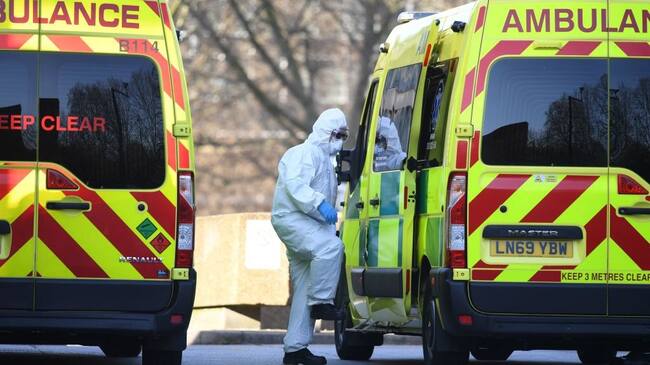 A member of the ambulance service wearing personal protective equipment is seen leading a patient (unseen) into an ambulance at St Thomas' Hospital in London on March 24, 2020. - Britain's leaders on Tuesday urged people to respect an unprecedented countrywide lockdown, saying that following advice to stay at home would stop people dying of coronavirus. (Photo by DANIEL LEAL-OLIVAS / AFP) (Photo by DANIEL LEAL-OLIVAS/AFP via Getty Images)