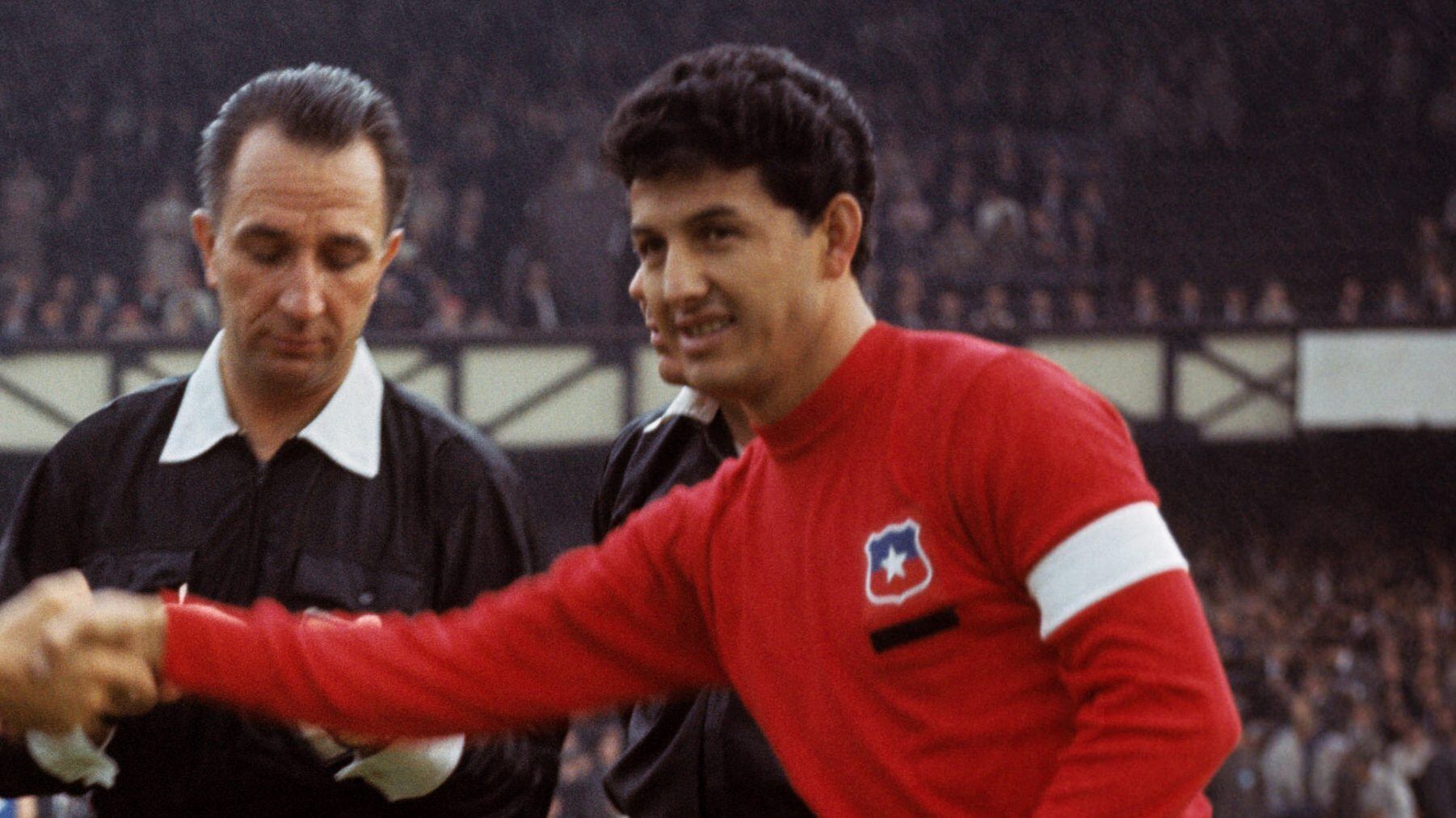 The two captains, Italy's Sandro Salvadore (l) and Chile's Leonel Sanchez (r), shake hands as referee Gottfried Dienst (c) looks on   (Photo by PA Images via Getty Images)