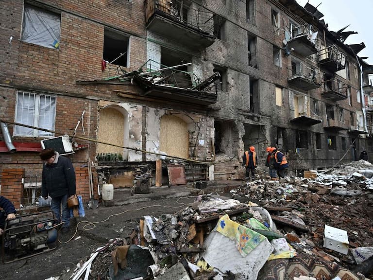 Trabajadores limpian los escombros que deja un ataque en Ucrania