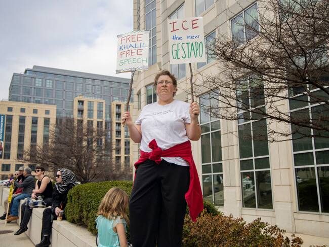 A protester stands outside the ICE building holding signs during a demonstration in Washington, DC, on March 15, 2025. The Palestinian Youth Movement organized the rally to demand the release of Mahmoud Kalil, a Palestinian student activist facing deportation from the United States. (Photo by Hanna Leka / Middle East Images / Middle East Images via AFP) (Photo by HANNA LEKA/Middle East Images/AFP via Getty Images)