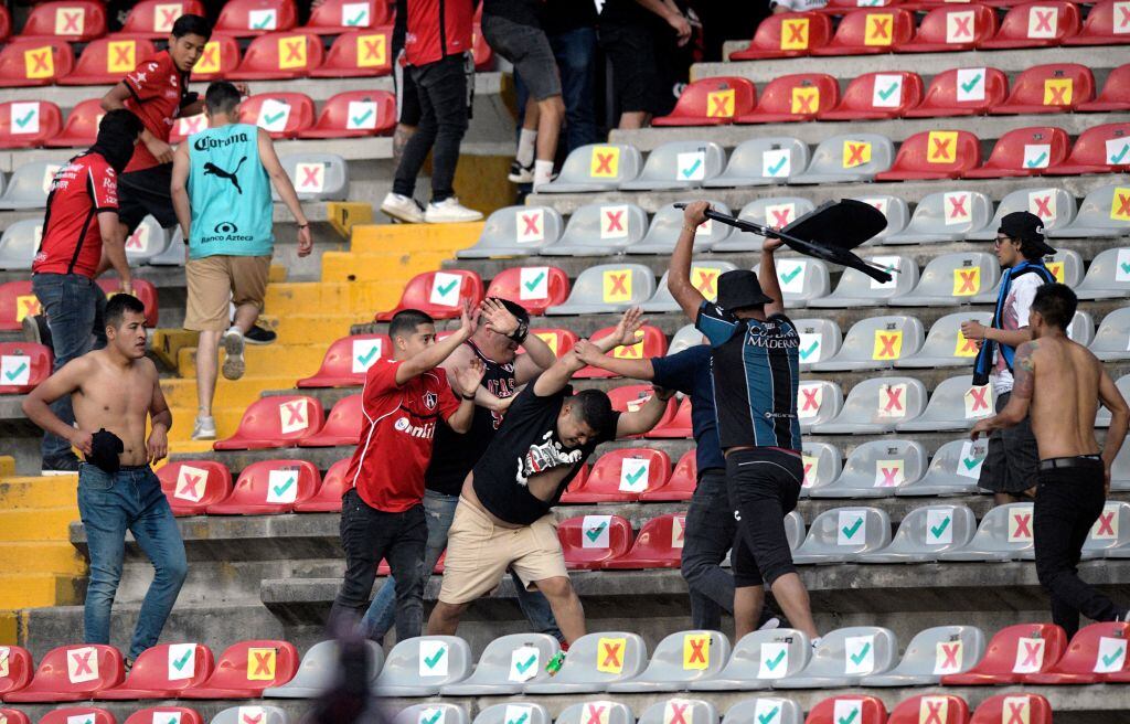Supporters of Atlas fight with supporters of Queretaro during the Mexican Clausura tournament football match between Queretaro and Atlas at Corregidora stadium in Queretaro, Mexico on March 5, 2022. - A match between Mexican football clubs was called off March 5, 2022 after violence by opposing fans spilled onto the field. The game between Queretaro and Atlas at La Corregidora stadium in the city of Queretaro -- the ninth round of the 2022 Clausura football tournament -- was in its 63rd minute when fights between opposing fans broke out. (Photo by AFP) (Photo by STR/AFP via Getty Images)