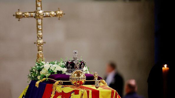 LONDON, ENGLAND - SEPTEMBER 18: A view of Queen Elizabeth's coffin, draped in the Royal Standard, with the Imperial State Crown and flowers on top, following her death, during her lying-in-state at Westminster Hall on September 18, 2022 in London, England. Members of the public are able to pay respects to Her Majesty Queen Elizabeth II for 23 hours a day from 17:00 on September 18, 2022 until 06:30 on September 19, 2022. Queen Elizabeth II died at Balmoral Castle in Scotland on September 8, 2022, and is succeeded by her eldest son, King Charles III. (Photo by Sarah Meyssonnier-WPA Pool/Getty Images)