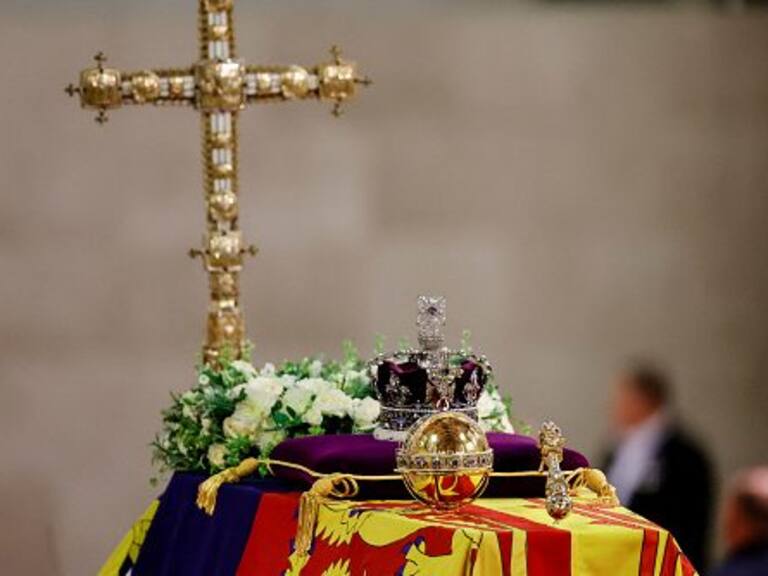 LONDON, ENGLAND - SEPTEMBER 18: A view of Queen Elizabeth's coffin, draped in the Royal Standard, with the Imperial State Crown and flowers on top, following her death, during her lying-in-state at Westminster Hall on September 18, 2022 in London, England. Members of the public are able to pay respects to Her Majesty Queen Elizabeth II for 23 hours a day from 17:00 on September 18, 2022 until 06:30 on September 19, 2022. Queen Elizabeth II died at Balmoral Castle in Scotland on September 8, 2022, and is succeeded by her eldest son, King Charles III. (Photo by Sarah Meyssonnier-WPA Pool/Getty Images)