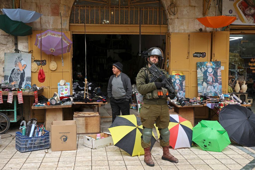 Soldados israelíes custodian mercado en la zona ocupada en West Bank