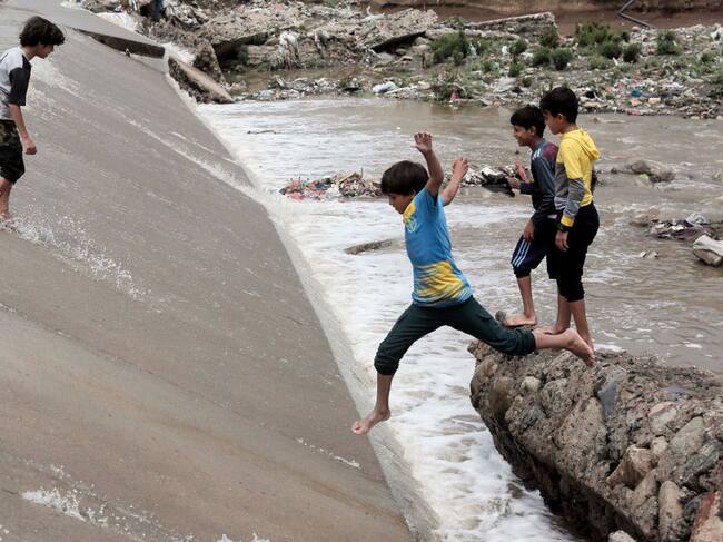 Un grupo de niños juega sobre las calles inundadas tras las lluvias torrenciales en Yemen.