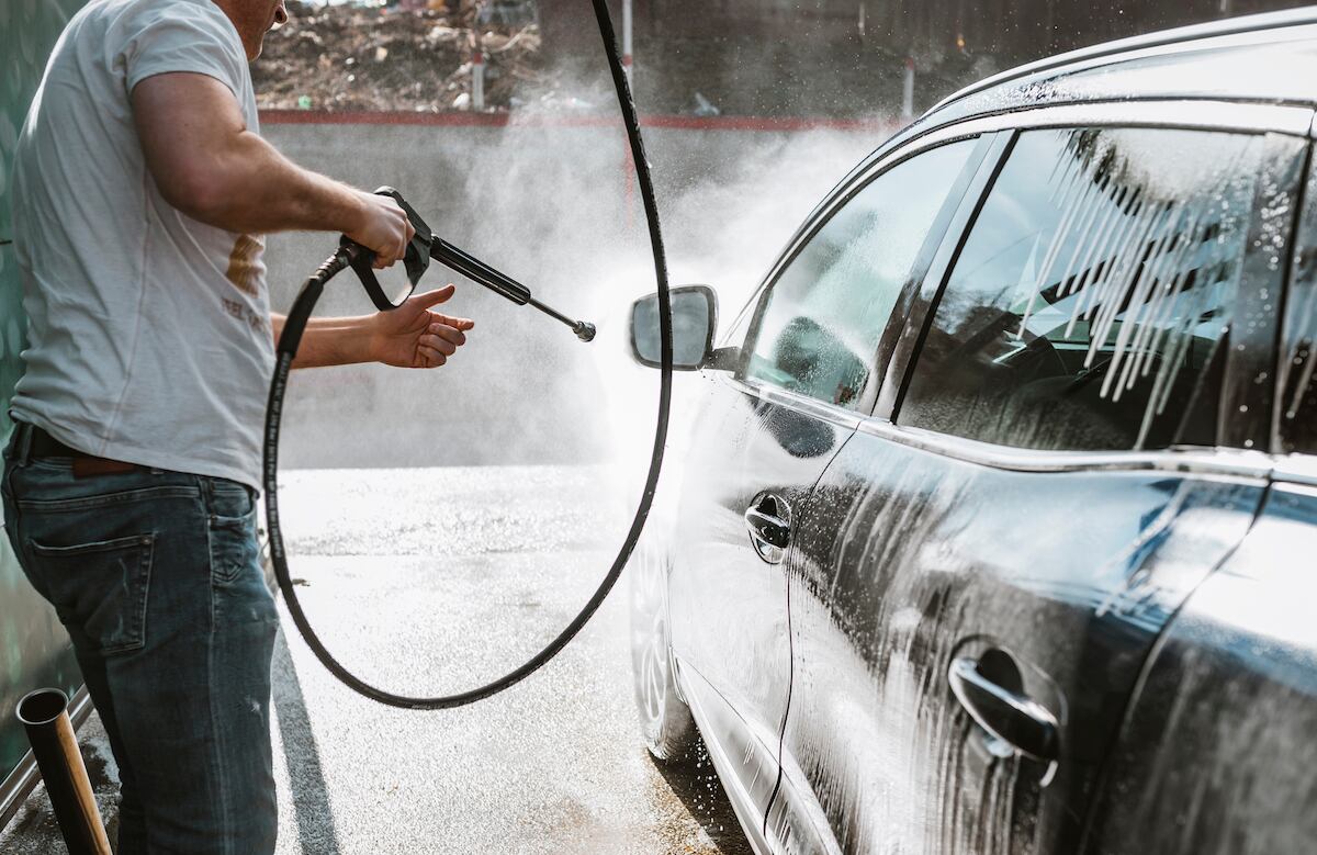Imagen referencial de un hombre lavando un auto