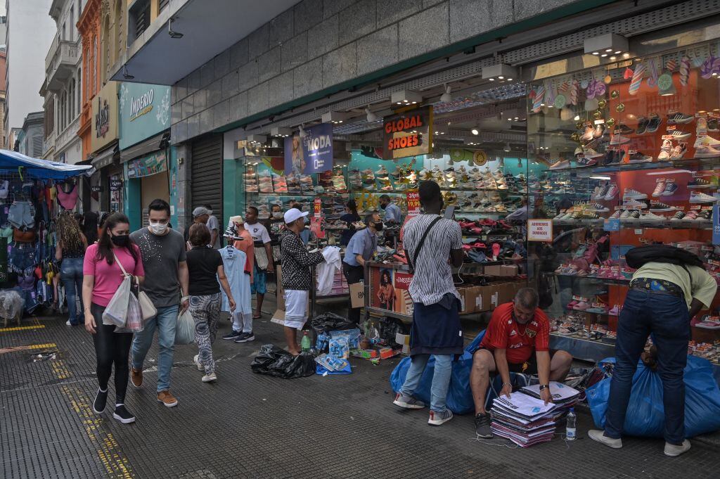 Las personas pasan frente a las tiendas comerciales en Sao Paulo de Brasil