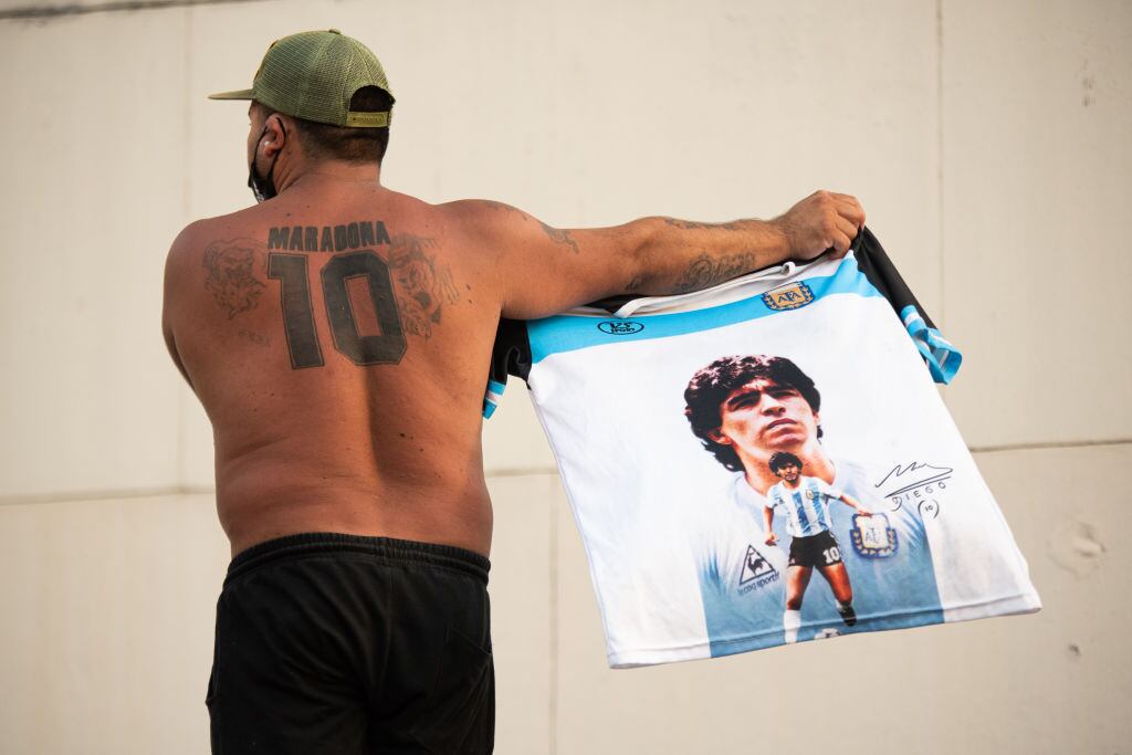 Hincha argentino muestra una camiseta y un tatuaje de Maradona