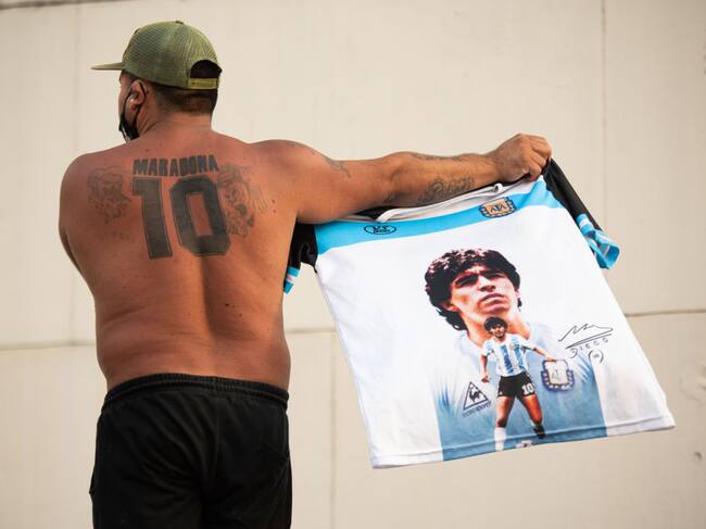 Hincha argentino muestra una camiseta y un tatuaje de Maradona