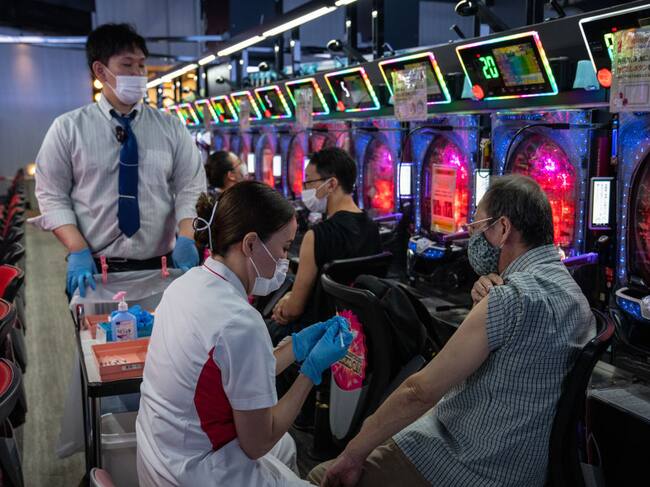 Trabajadores de la salud vacunan contra el Covid-19 en un centro de juegos en Osaka