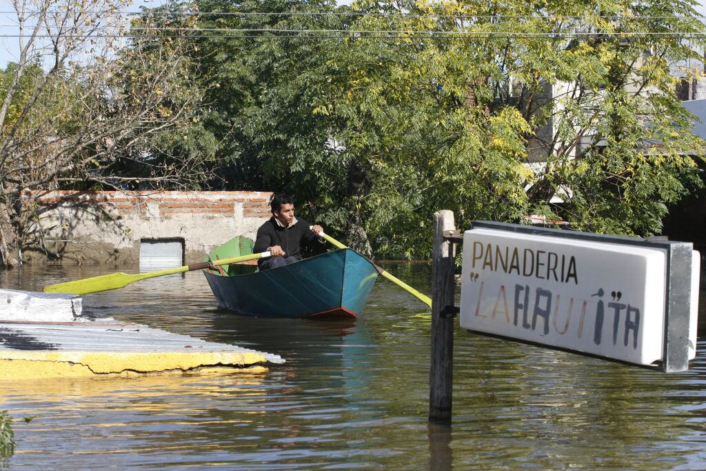 A man rows in a street of a flooded neighborhood of Durazno city, some 200 km north of Montevideo, 09 May, 2007. About 12,000 people were evacuated from their houses in the most important flood in Uruguay in the last 50 years. AFP PHOTO/Miguel ROJO (Photo by MIGUEL ROJO / AFP) (Photo by MIGUEL ROJO/AFP via Getty Images)