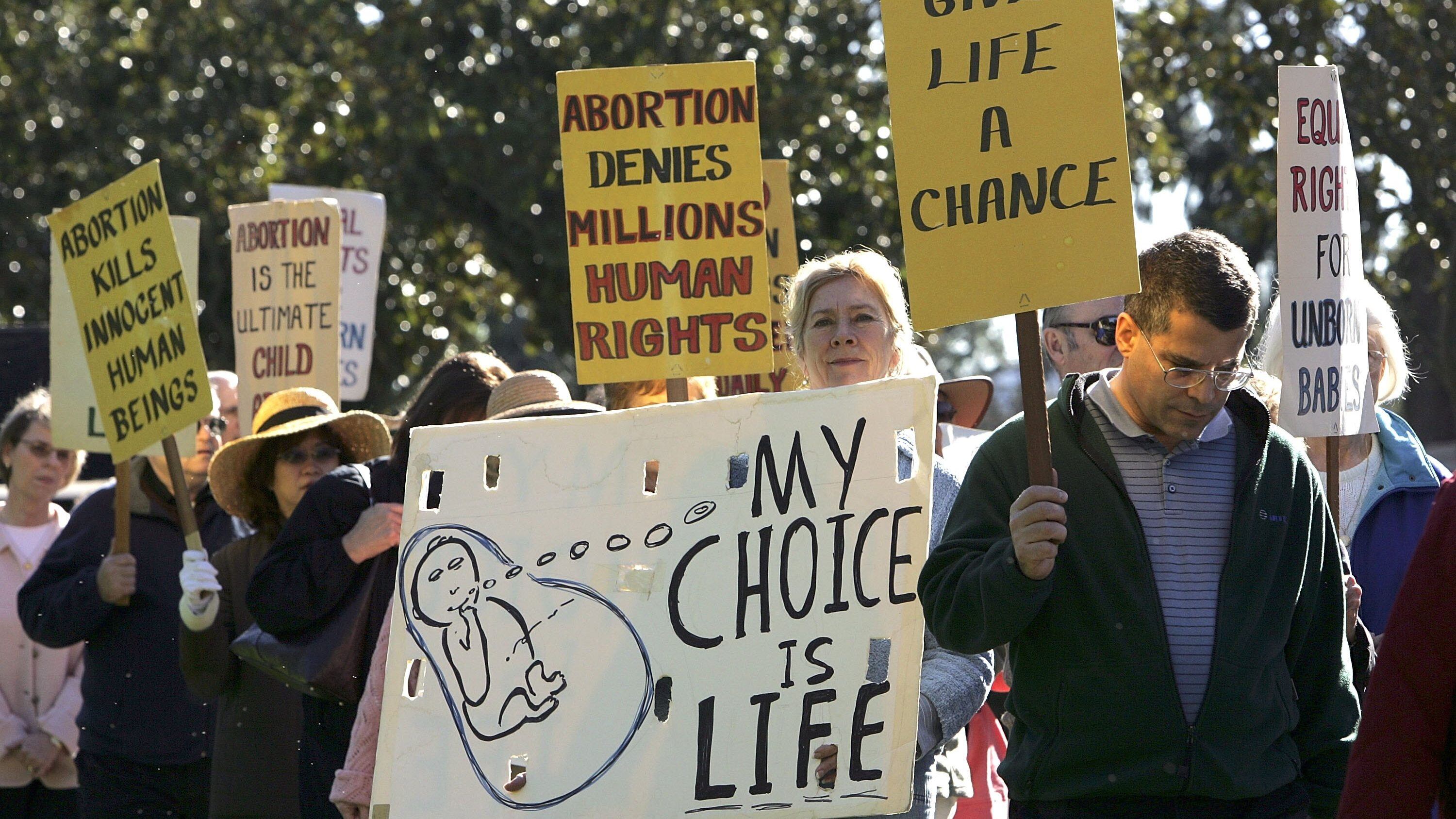 LOS ALTOS, CA - JANUARY 23: Pro-life demonstrators carry signs as they march January 23, 2006 in downtown Los Altos, California. Dozens of pro-life supporters from St. Nicholas Church marched to mark the 33rd anniversary of the supreme court decision to legalize abortion. (Photo by Justin Sullivan/Getty Images)