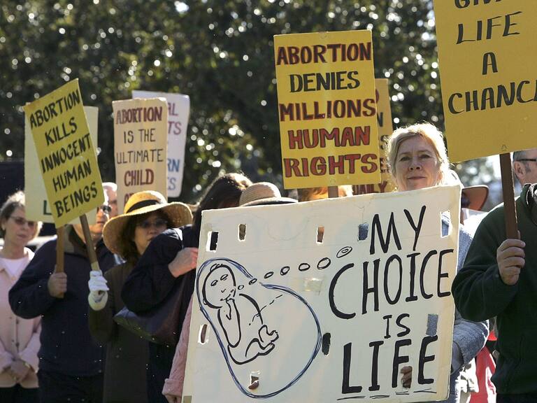 LOS ALTOS, CA - JANUARY 23: Pro-life demonstrators carry signs as they march January 23, 2006 in downtown Los Altos, California. Dozens of pro-life supporters from St. Nicholas Church marched to mark the 33rd anniversary of the supreme court decision to legalize abortion. (Photo by Justin Sullivan/Getty Images)