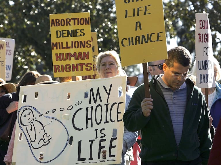 LOS ALTOS, CA - JANUARY 23:  Pro-life demonstrators carry signs as they march January 23, 2006 in downtown Los Altos, California. Dozens of pro-life supporters from St. Nicholas Church marched to mark the 33rd anniversary of the supreme court decision to legalize abortion.  (Photo by Justin Sullivan/Getty Images)
