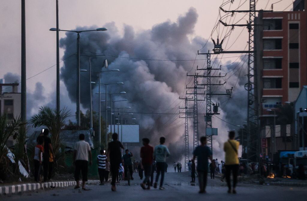 Un grupo de palestinos observa el humo que se levanta tras un nuevo bombardeo de Israel contra la Franja de Gaza.