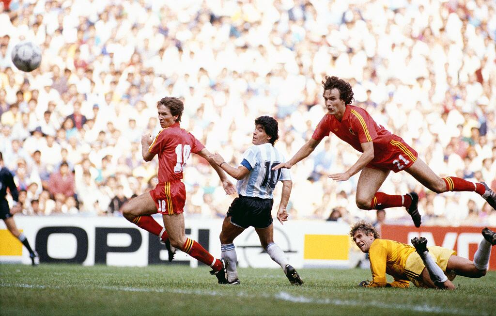 MEXICO CITY, MEXICO - JUNE 25:  Diego Maradona (c) of Argentina scores the first goal during the 1986 FIFA World Cup semi-final between Argentina and Belguim at the Azteca Stadium on June 25, 1986 in Mexico City, Mexico.  (Photo by Mike King/Allsport/Getty Images)