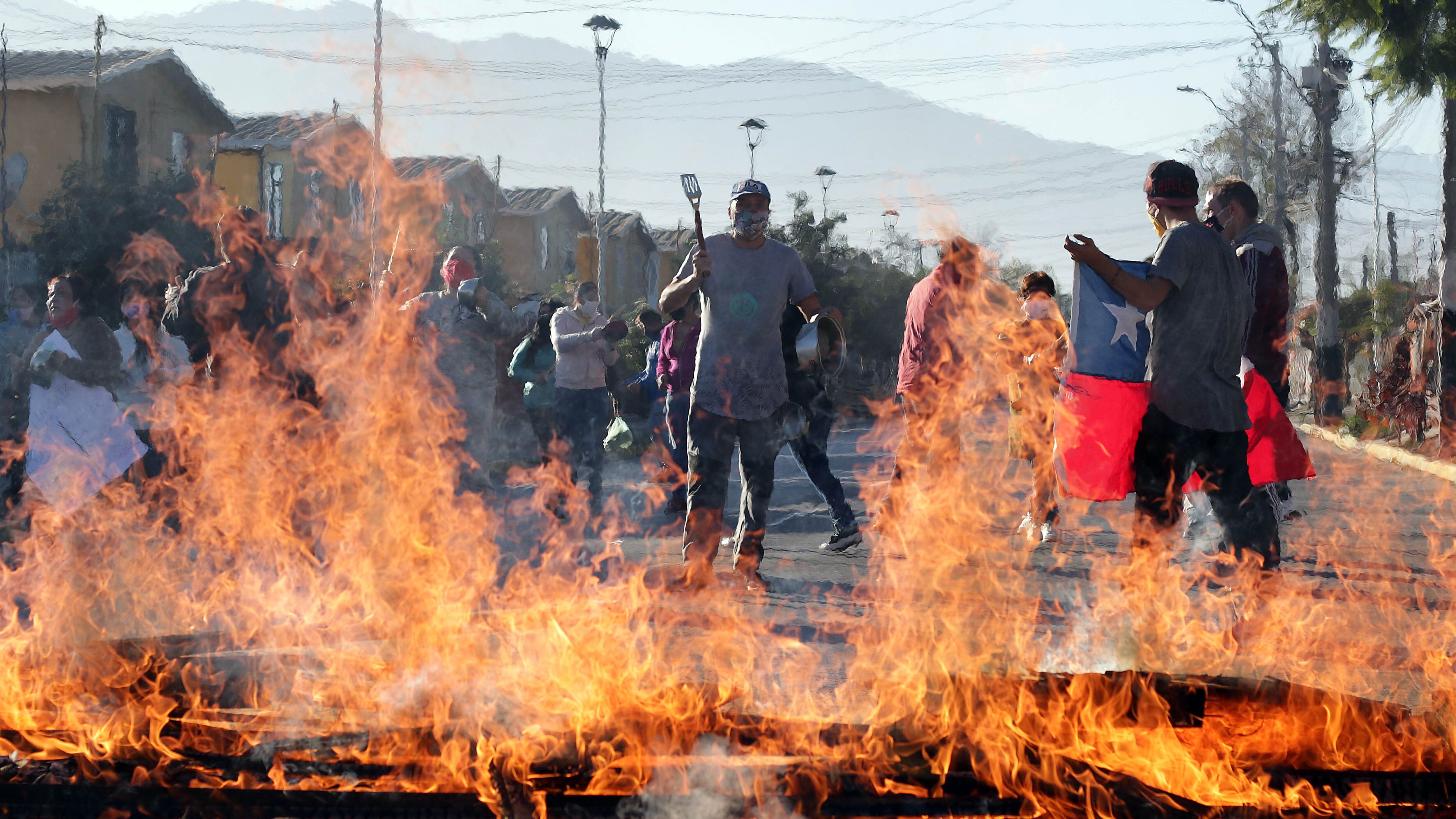 25 de Mayo del 2020/SANTIAGO Vecinos de la villa Los Lirios de la comuna de La Pintana, protestan por lo que ellos indican , la nula ayuda que han recibido por parte del municipio durante la pandemia. En la imagen un hombre toca la cacerola en medio de una barricada
FOTO: FRANCISCO CASTILLO /AGENCIAUNO