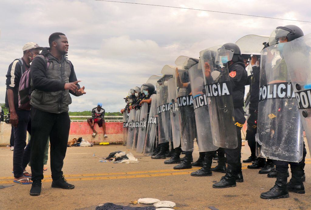 Policías impiden el paso de migrantes en el puente que une Brasil con Perú