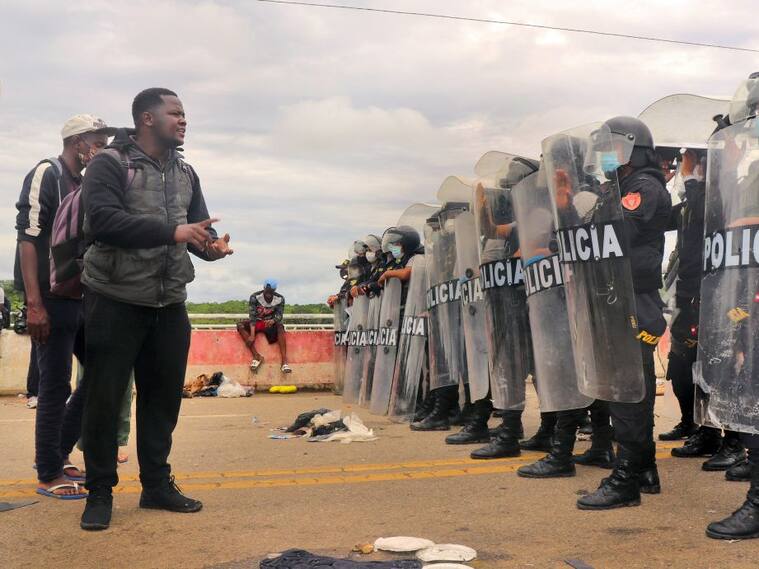 Policías impiden el paso de migrantes en el puente que une Brasil con Perú