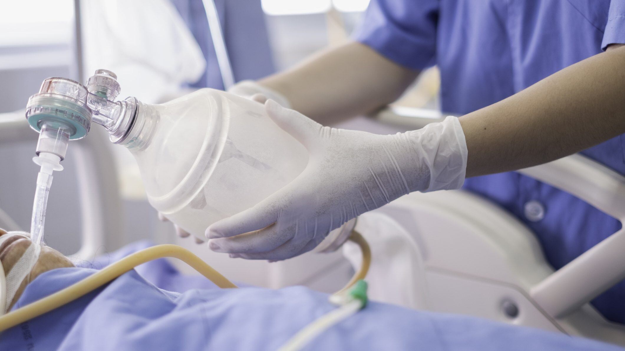 doctor holding oxygen ambu bag over patient given oxygen to patient by intubation tube in ICU/Emergency room