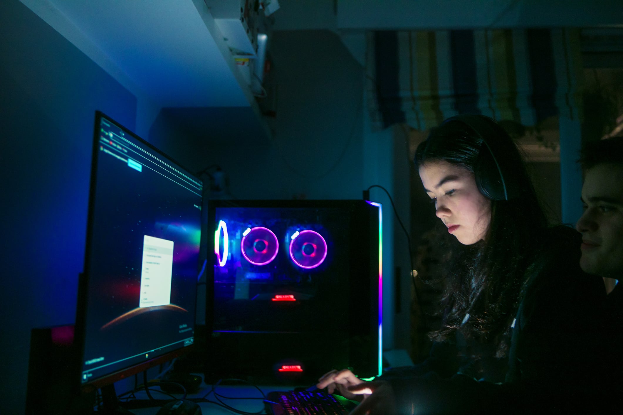 female teenager gamer playing computer video games in the night.