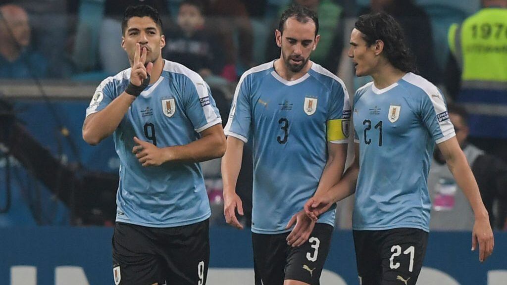Uruguay's Luis Suarez(L) celebrates with teammates Uruguay's Edinson Cavani(R) and Uruguay's Diego Godin after scoring during the Copa America football tournament Group C match between Uruguay and Japan at the Gremio Arena Stadium in Porto Alegre, Brazil, on June 20, 2019. (Photo by Carl DE SOUZA / AFP) (Photo credit should read CARL DE SOUZA/AFP via Getty Images)