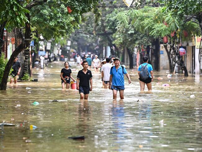 Las personas avanzan por las calles de la ciudad de Hanói en Vietnam tras el paso del supertifón Yagi