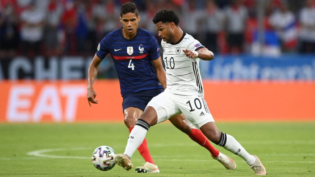 MUNICH, GERMANY - JUNE 15: Serge Gnabry of Germany is closed down by Raphael Varane of France during the UEFA Euro 2020 Championship Group F match between France and Germany at Football Arena Munich on June 15, 2021 in Munich, Germany. (Photo by Matthias Hangst/Getty Images)