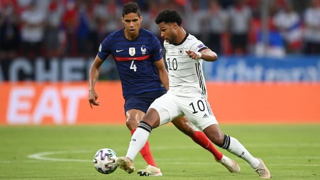 MUNICH, GERMANY - JUNE 15: Serge Gnabry of Germany is closed down by Raphael Varane of France during the UEFA Euro 2020 Championship Group F match between France and Germany at Football Arena Munich on June 15, 2021 in Munich, Germany. (Photo by Matthias Hangst/Getty Images)